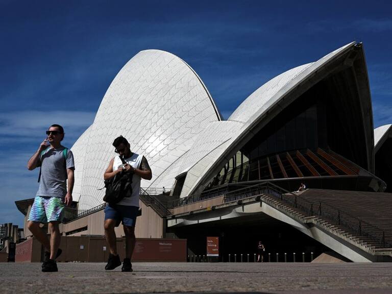 Australianos caminan frente a la Ópera de Sídney