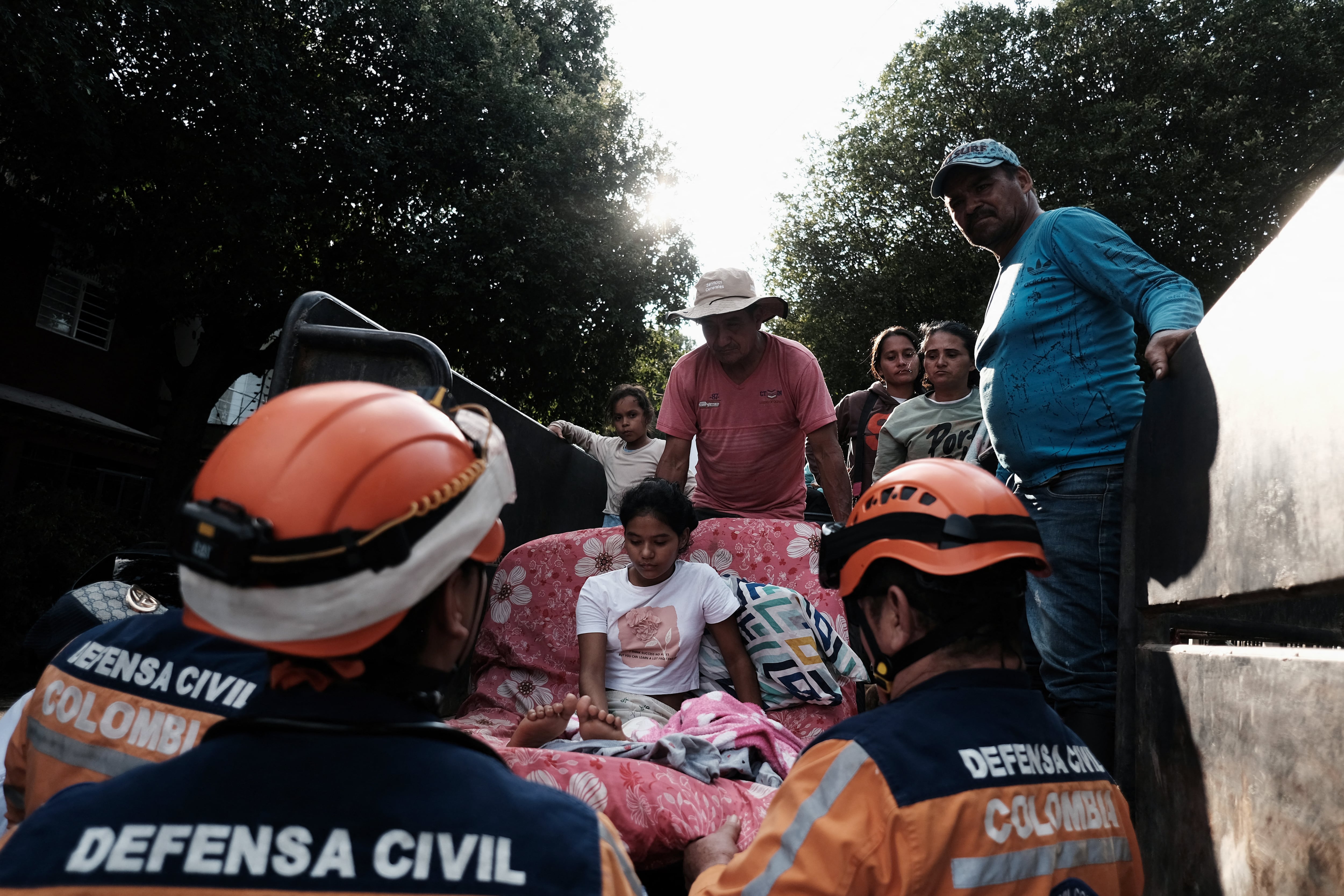Civil defense members help a child as displaced people from recent clashes between armed groups take shelter at the General Santander Stadium in Cucuta, Norte de Santander Department, Colombia on January 19, 2025. A fresh outbreak of guerrilla violence amid a faltering peace process in conflict-riddled Colombia has left more than 80 people dead in just over three days, officials reported Sunday. The National Liberation Army (ELN) armed group launched an assault in the northeastern Catatumbo region last Thursday on a rival formation comprised of ex-members of the now-defunct FARC guerrilla force who kept fighting after it disarmed in 2017. (Photo by STR photographer / AFP) (Photo by STR PHOTOGRAPHER/AFP via Getty Images)