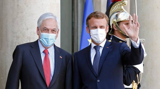 PARIS, FRANCE - SEPTEMBER 06: French President Emmanuel Macron (R) wearing a protective face mask waves as he welcomes Chilean President Sebastian Pinera prior to a working lunch at the Elysee Presidential Palace on September 06, 2021 in Paris, France. Sebastian Pinera is in Paris for an official one-day visit. (Photo by Chesnot/Getty Images)
