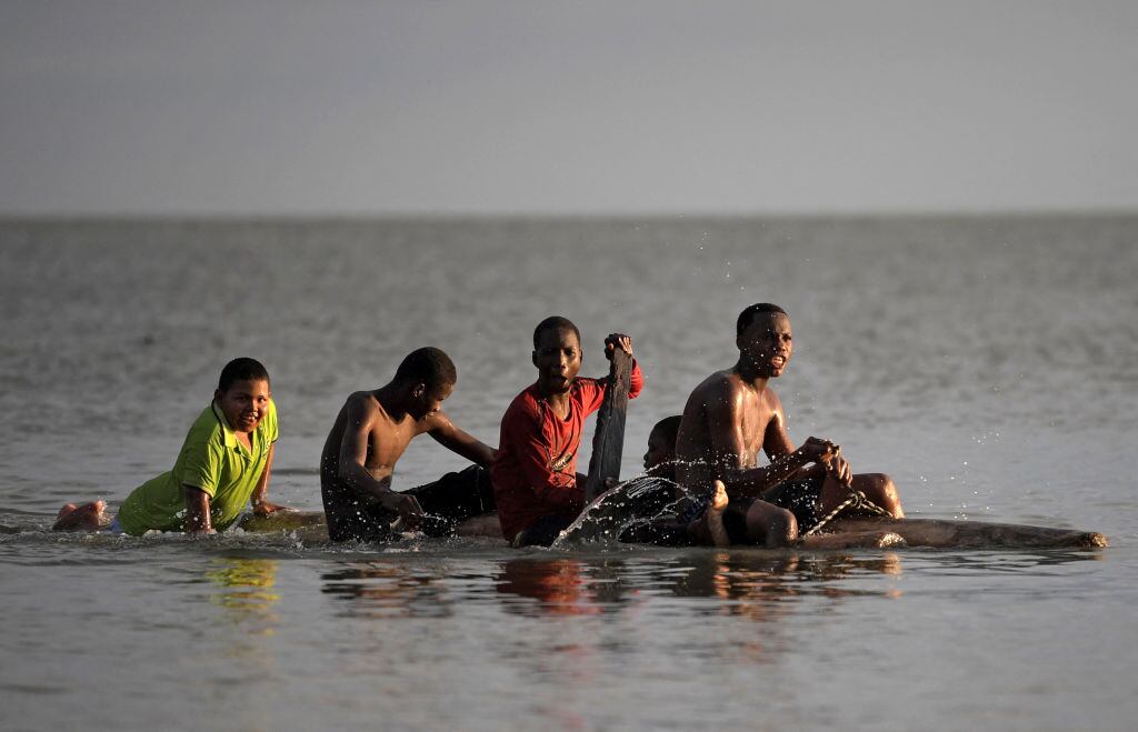 Migrantes suben a una balsa para navegar por el mar Caribe