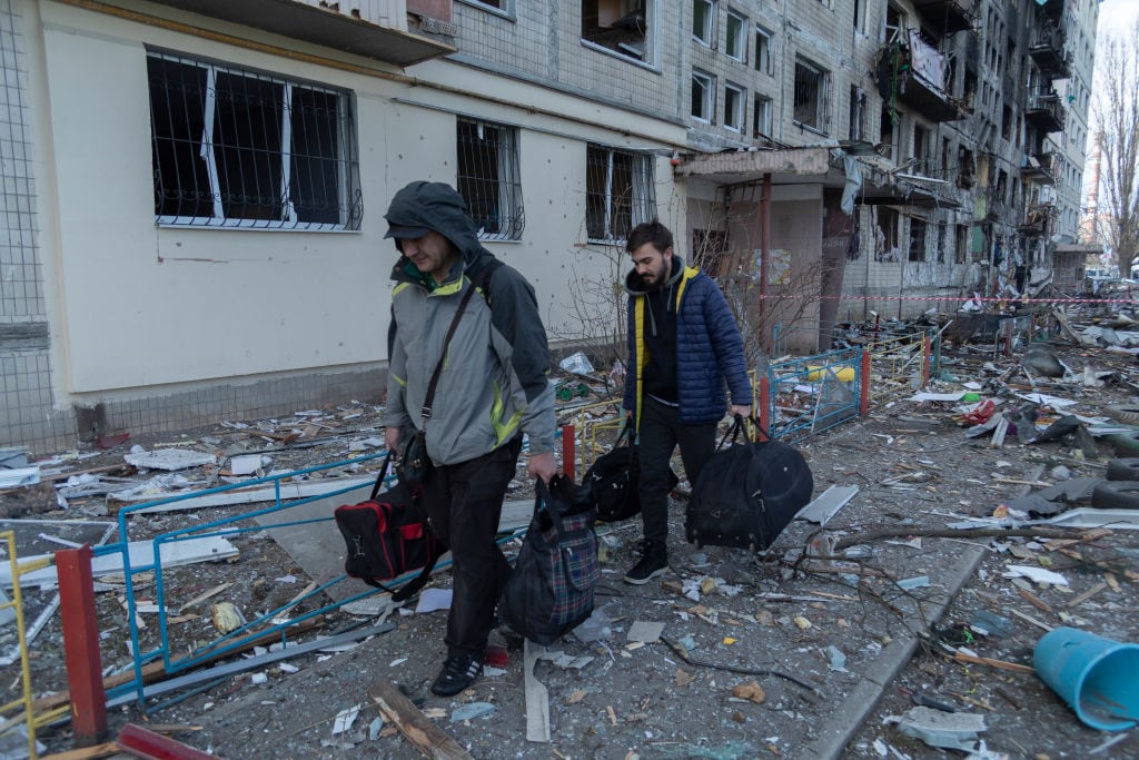 Personas abandonan un edificio tras el ataque a un barrio de Kiev
