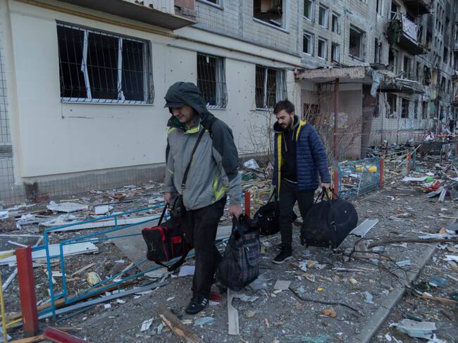 Personas abandonan un edificio tras el ataque a un barrio de Kiev