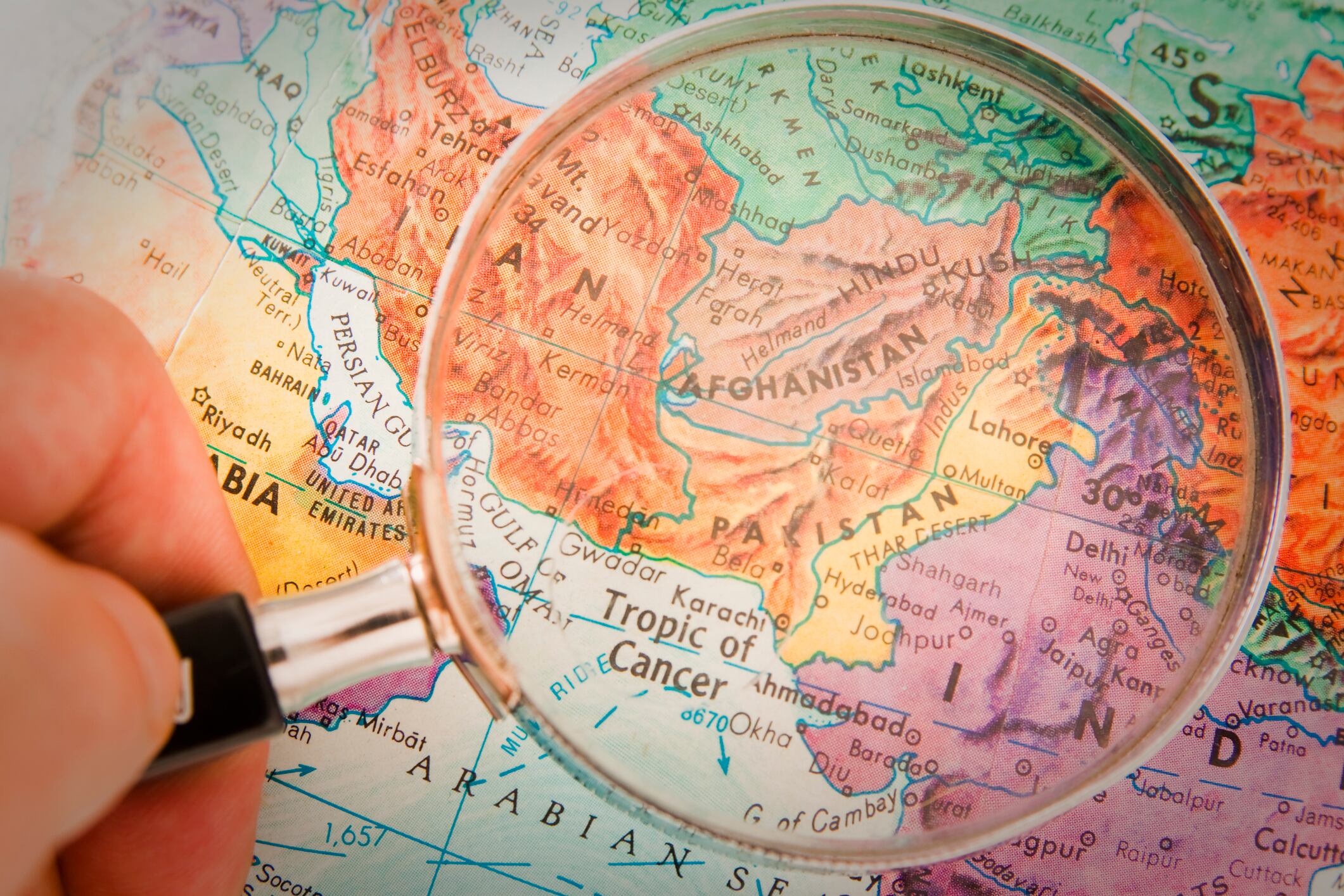 "Studying Geography - Photograph of Afghanistan, Pakistan and surrounding countries on retro globe underneath a magnifying glass."