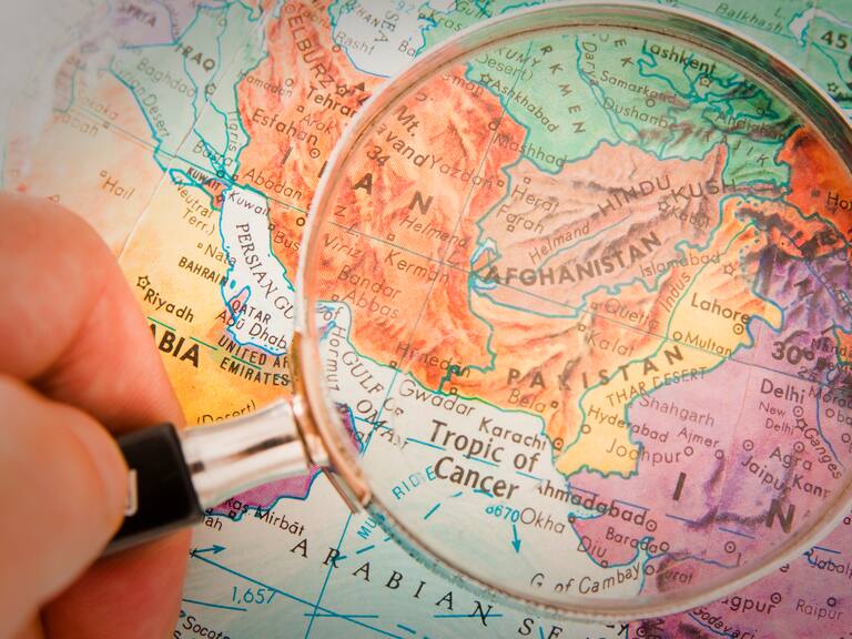 "Studying Geography - Photograph of Afghanistan, Pakistan and surrounding countries on retro globe underneath a magnifying glass."