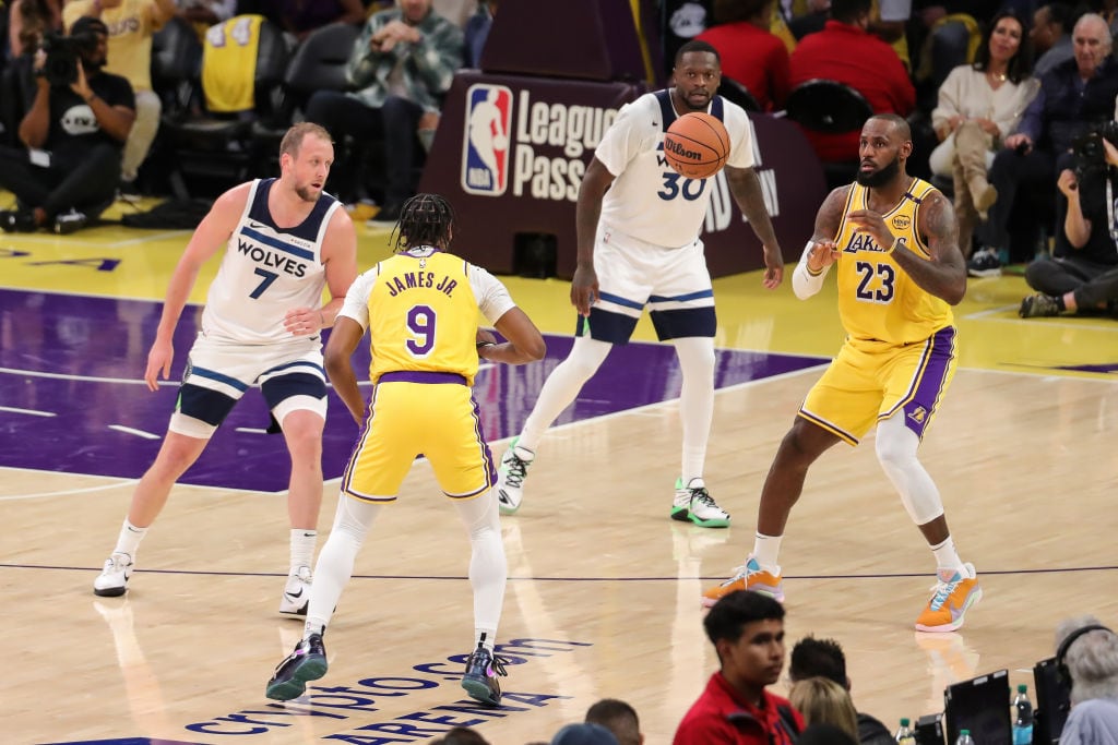 Bronny James le entrega el balón a su padre LeBron James durante el partido entre Los Angeles Lakers y Minnesota Timberwolves en California de EEUU