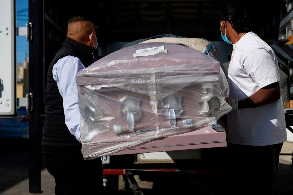 Trabajadores de funeraria transportan un ataúd en Los Angeles