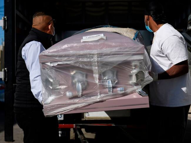 Trabajadores de funeraria transportan un ataúd en Los Angeles