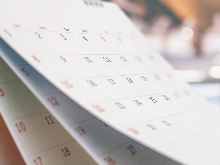 Close up white paper desk calendar with blurred bokeh background appointment and business meeting concept
