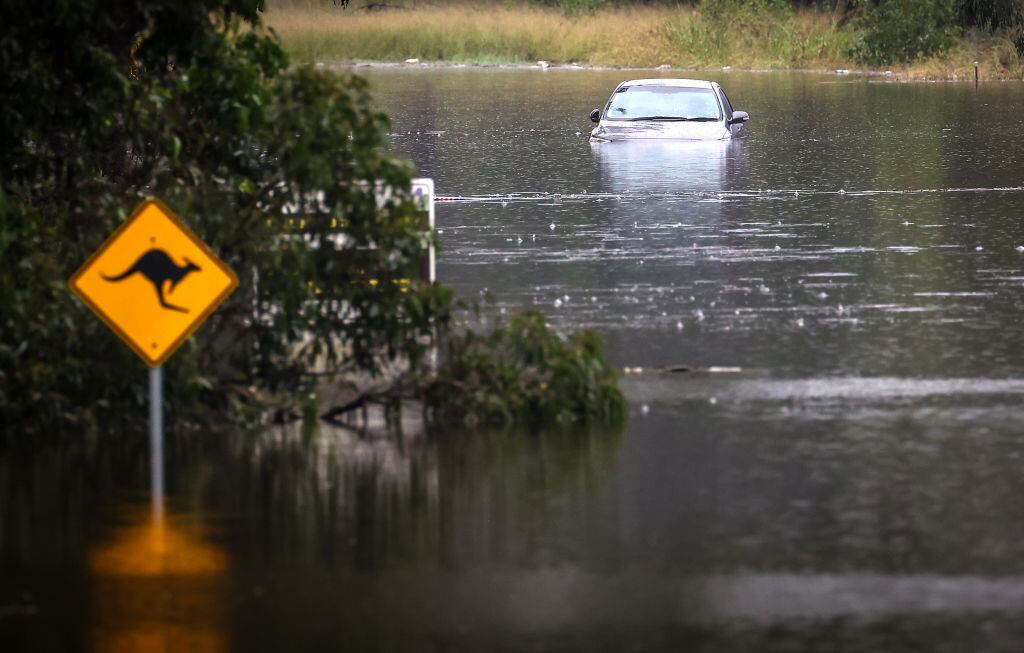 Una calle inundada y un auto parcialmente cubierto de agua en un barrio de Sídney