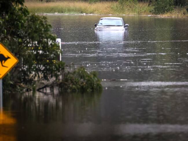 Una calle inundada y un auto parcialmente cubierto de agua en un barrio de Sídney