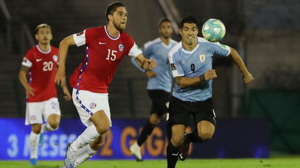 MONTEVIDEO, URUGUAY - OCTOBER 08: Luis Suarez of Uruguay fights for the ball with Francisco Sierralta of Chile during a match between Uruguay and Chile as part of South American Qualifiers for Qatar 2022 at Centenario Stadium on October 08, 2020 in Montevideo, Uruguay. (Photo by Raul Martinez -Pool/Getty Images)