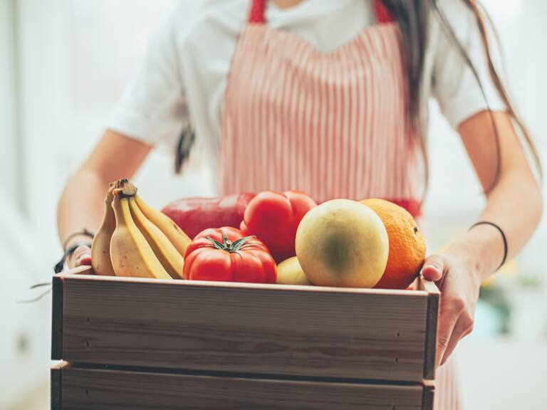 Woman holding box of grocery food and from store. Online grocery shopping service concept