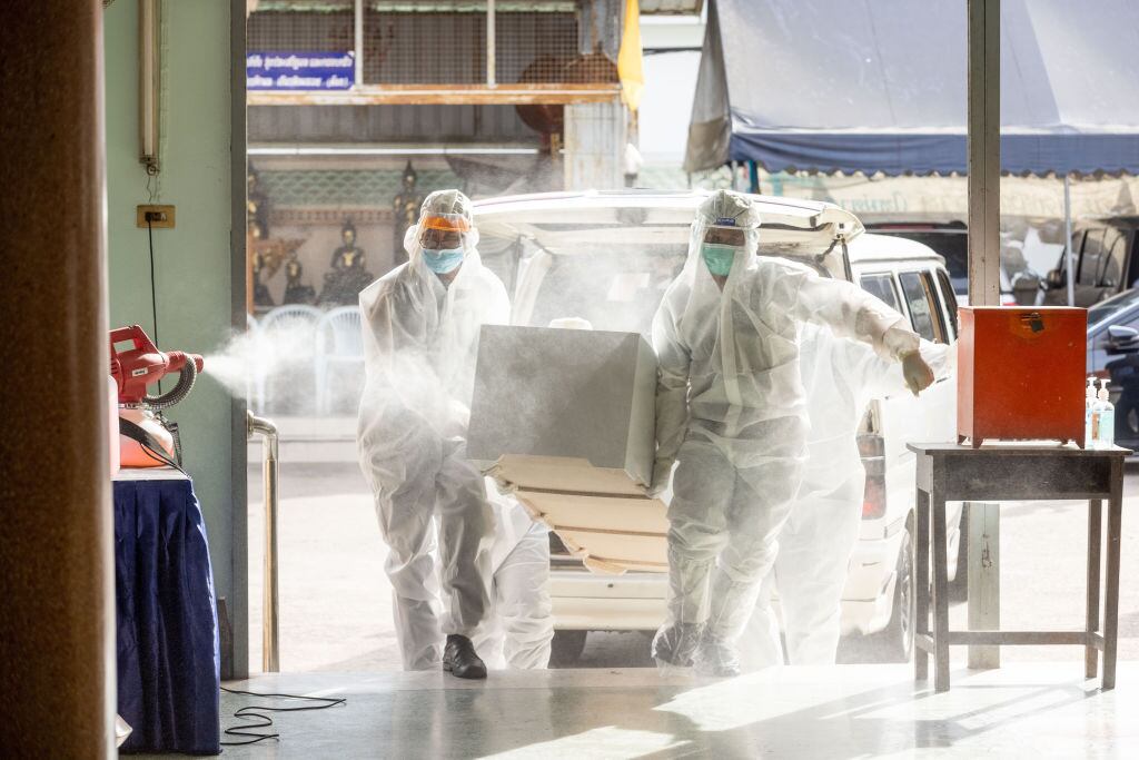 Trabajadores llevan a una víctima del Covid-19 a un incinerador en Tailandia