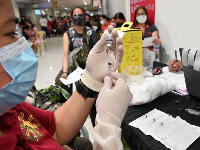 Trabajadores médicos preparan dosis anticovid en un centro vacunatorio