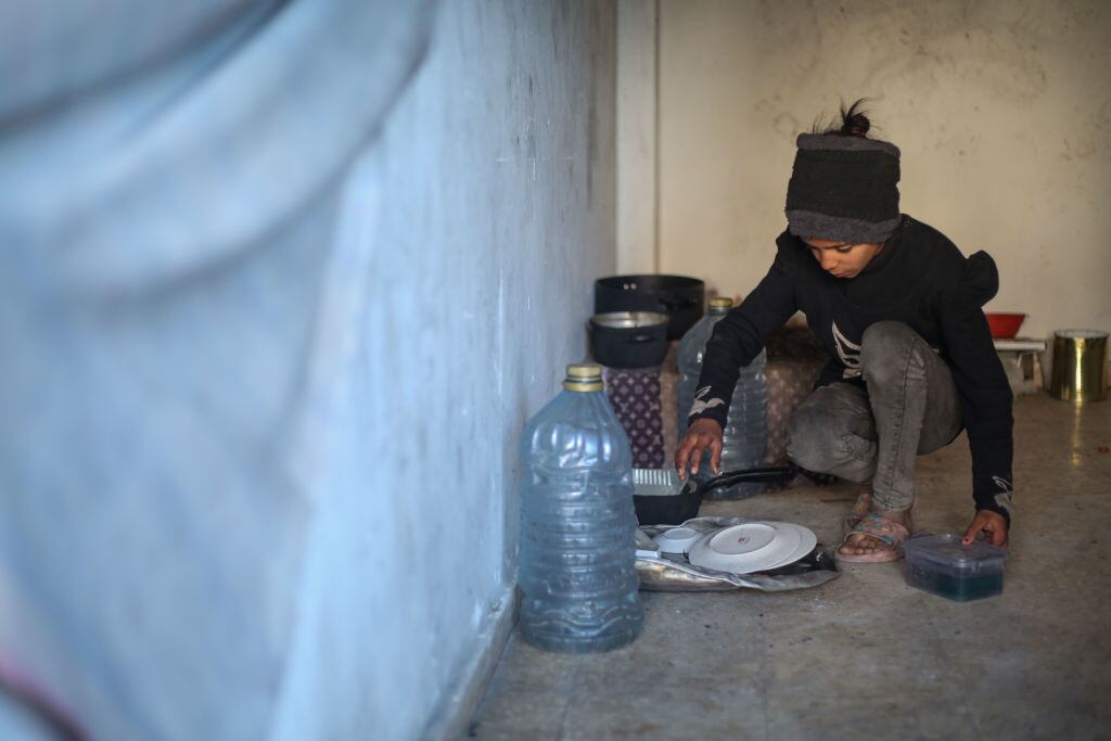 Un niño de una familia palestina desplazada en la Franja de Gaza, por los ataques de Israel, busca alimentarse en medio de la crisis humanitaria.