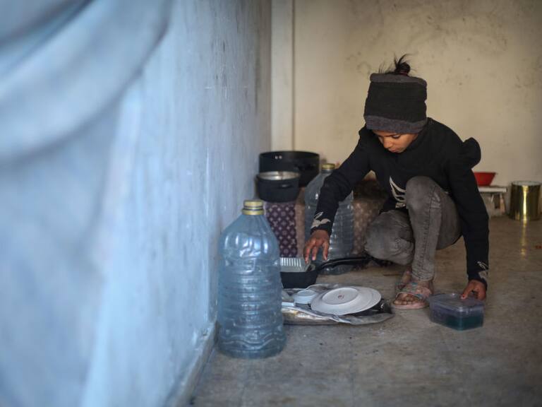 Un niño de una familia palestina desplazada en la Franja de Gaza, por los ataques de Israel, busca alimentarse en medio de la crisis humanitaria.