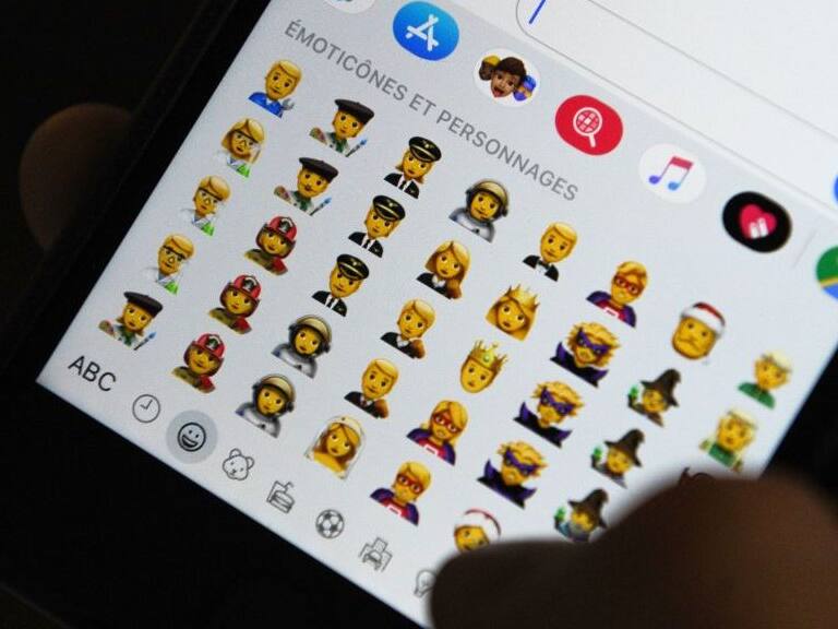 TOPSHOT - A person holds an iPhone showing emojis in Hong Kong, on October 30, 2019. - Apple has put out new gender neutral emojis of most of its people icons -- including punks, clowns and zombies -- as part of an update to its mobile operating system.The tech giant has offered growing numbers of inclusive designs in recent years, putting out a range of skin tones and occupations, with Google&#039;s Android publishing its own non-binary faces in May. (Photo by TENGKU Bahar / AFP) (Photo by TENGKU BAHAR/AFP via Getty Images)