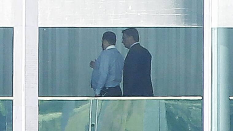 Brazilian President Jair Bolsonaro (R) is pictured with an adviser, inside Alvorada Palace in Brasilia, on March 12, 2020 after being tested for the new coronavirus COVID-19 after a top aide contracted the disease following a trip on which both met with US President Donald Trump. (Photo by Sergio LIMA / AFP) (Photo by SERGIO LIMA/AFP via Getty Images)