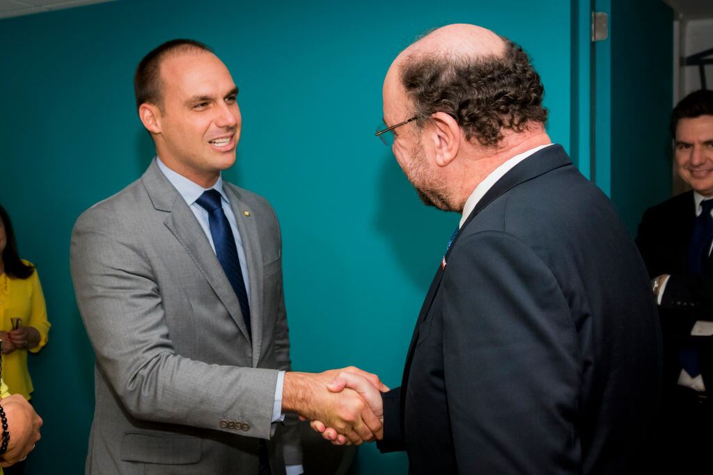 Eduardo Bolsonaro se saluda con el exministro chileno Alfredo Moreno