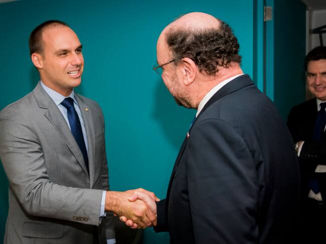 Eduardo Bolsonaro se saluda con el exministro chileno Alfredo Moreno