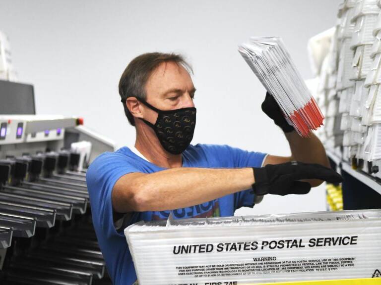 Michael Duve places mail-in ballots into trays in the sorting room at the Orange County Supervisor of Elections office on October 26, 2020 in Orlando, Florida. With nine days until the November 3 election, more people already have cast ballots in this years presidential election than voted early or absentee in the 2016 race. (Photo by Paul Hennessy/NurPhoto via Getty Images)