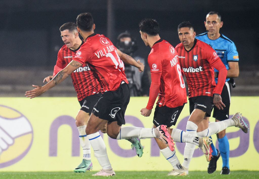 Huachipato's Paraguayan forward Cris Martinez (L) celebrates with teammates after scoring his team's first goal during the Copa Sudamericana knockout round playoff second leg football match between Uruguay's Racing and Chile's Huachipato at the Centenario stadium in Montevideo on July 23, 2024. (Photo by DANTE FERNANDEZ / AFP) (Photo by DANTE FERNANDEZ/AFP via Getty Images)