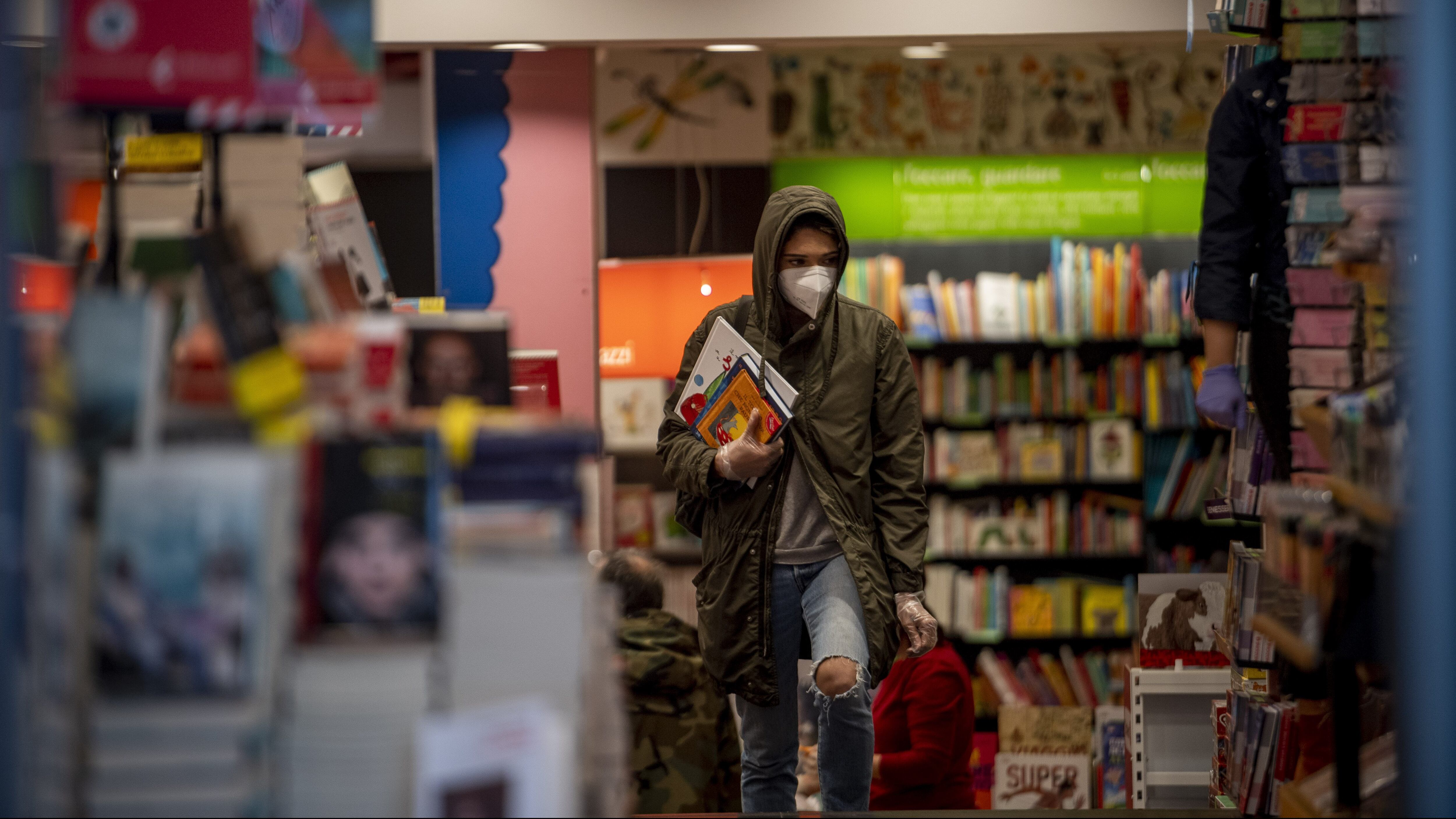 ROME, ITALY - APRIL 20: People wearing a protective mask buy books in the bookstore La Feltrinelli, following the government's decision to reopen some businesses including bookstores during the Coronavirus (COVID-19) pandemic on April 20, 2020, in Rome, Italy. The Italian government continues to enforce the nationwide lockdown measures to control the spread of COVID-19, even if some businesses categories are slowly reopening. The Coronavirus (COVID-19) pandemic has spread to many countries across the world, claiming over 160,000 lives and infecting over 2.4 million people. (Photo by Antonio Masiello/Getty Images)