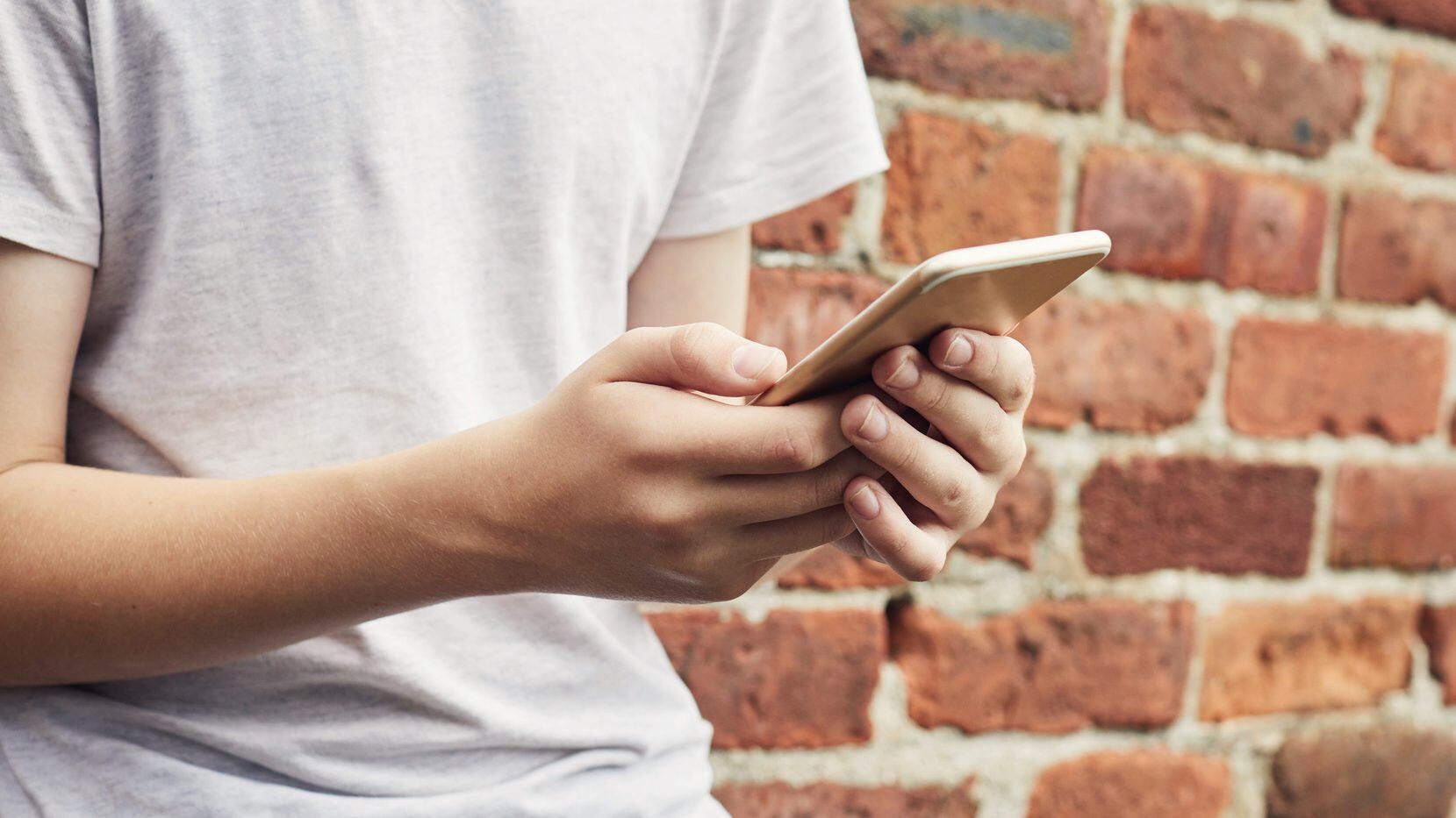 Close up of a teenage boys hands using a smartphone