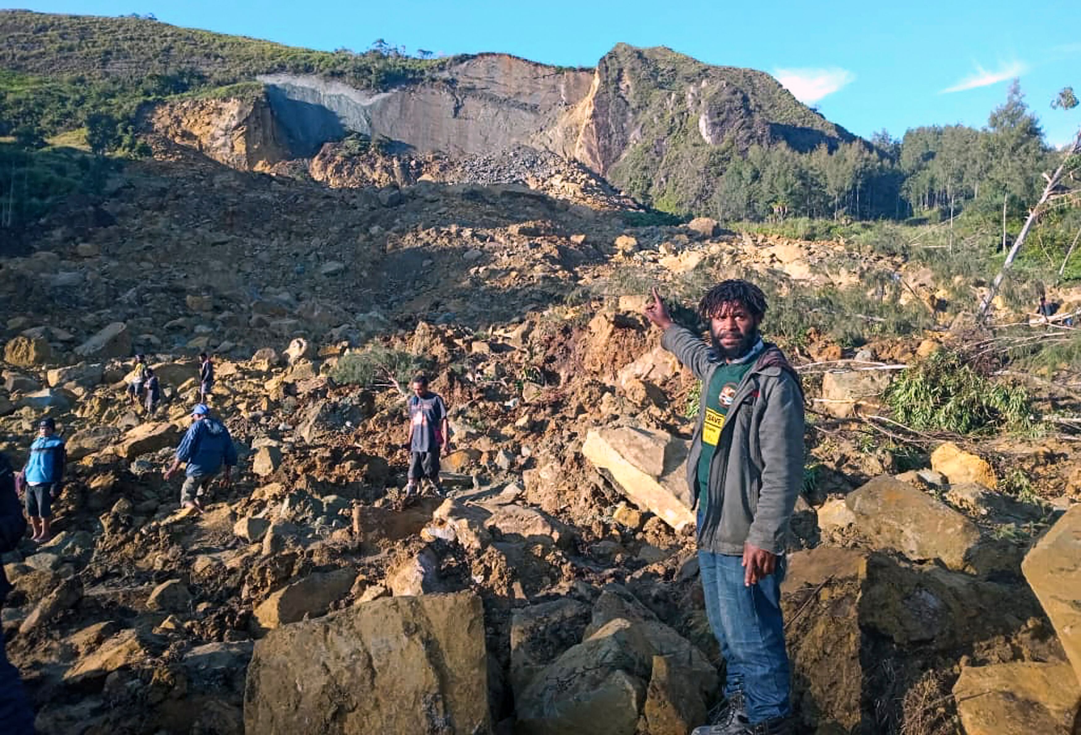 TOPSHOT - CORRECTION / People gather at the site of a landslide in Maip Mulitaka in Papua New Guinea's Enga Province on May 24, 2024. Local officials and aid groups said a massive landslide struck a village in Papua New Guinea's highlands on May 24, with many feared dead. (Photo by AFP) / "The erroneous mention[s] appearing in the metadata of this photo by STR has been modified in AFP systems in the following manner: [Maip Mulitaka] instead of [Port Moresby]. Please immediately remove the erroneous mention[s] from all your online services and delete it (them) from your servers. If you have been authorized by AFP to distribute it (them) to third parties, please ensure that the same actions are carried out by them. Failure to promptly comply with these instructions will entail liability on your part for any continued or post notification usage. Therefore we thank you very much for all your attention and prompt action. We are sorry for the inconvenience this notification may cause and remain at your disposal for any further information you may require." (Photo by STR/AFP via Getty Images)