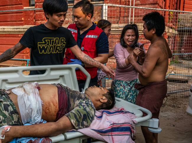 Personas observan a un herido por la represión en Myanmar