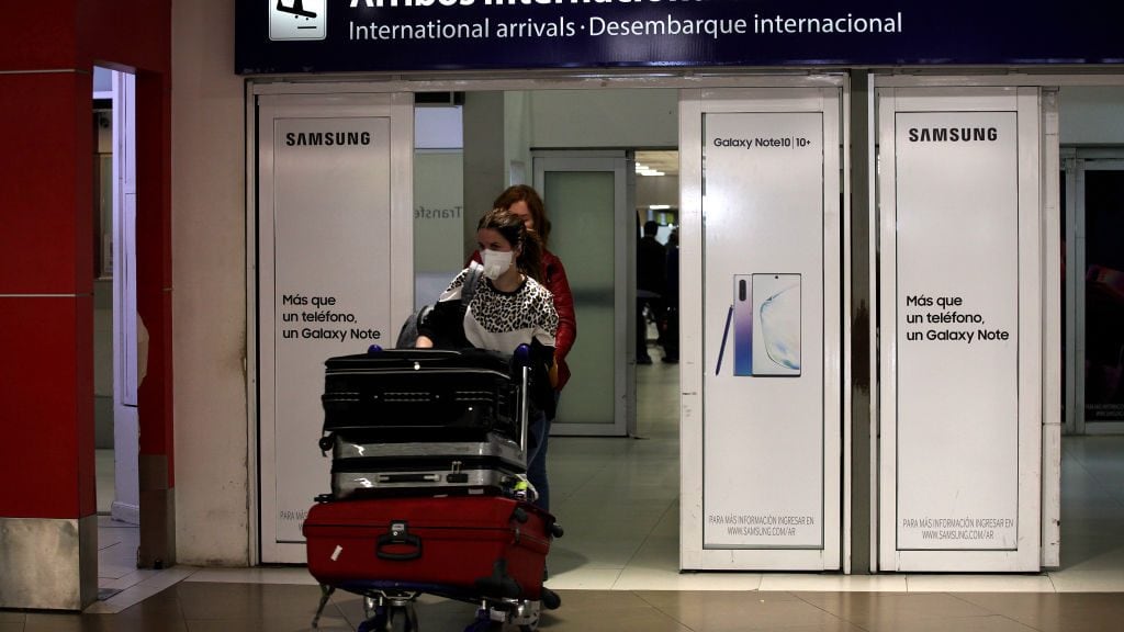 Traveler wearing protective mask arrives at Ezeiza International Airport terminal on March 16, 2020 in Buenos Aires, Argentina. The president, Alberto Fernandez, decided to close the borders for 15 days, to control possible new cases, since in the last days the number of infected increased exponentially. The last flights from Europe arrive in Ezeiza and the controls are exauthentic. (Photo by Carol Smiljan/NurPhoto via Getty Images)