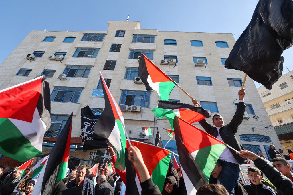 Manifestantes con banderas de Palestina a las afueras de la sede de la UNRWA en la localidad de Ramallah en Cisjordania.