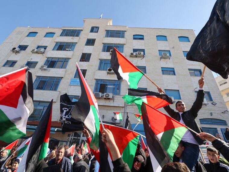 Manifestantes con banderas de Palestina a las afueras de la sede de la UNRWA en la localidad de Ramallah en Cisjordania.