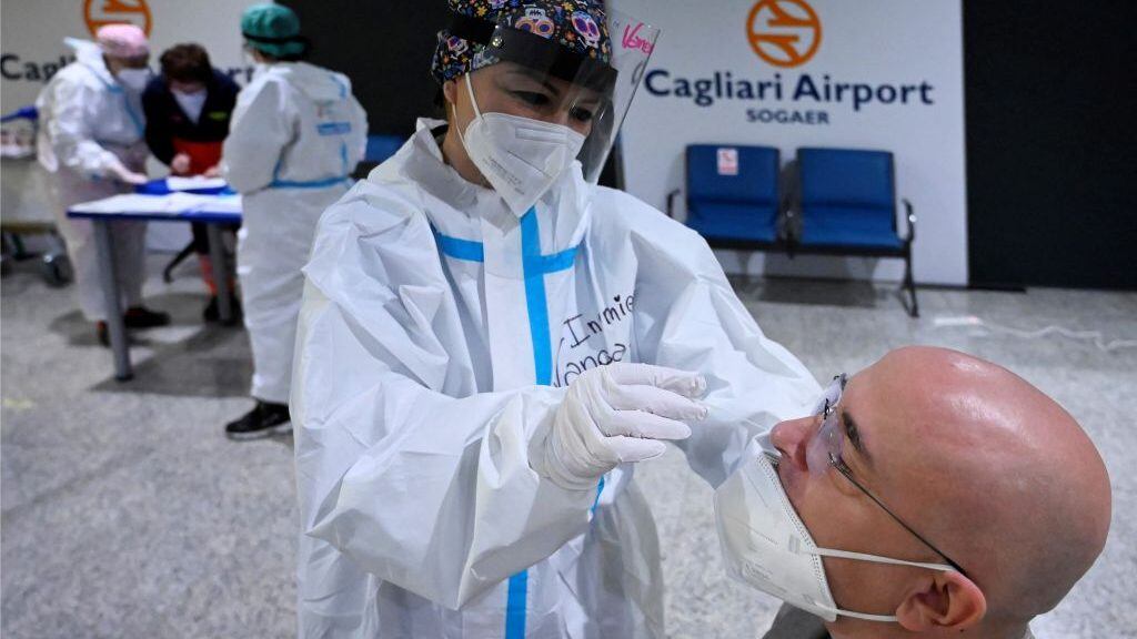 A nurse makes a PCR test to a passenger in the arrival area of Cagliari's airport, on March 15, 2021. - Sardinia is the only Italian region designated as low-risk and escaping Covid-19 restrictions. (Photo by Alberto PIZZOLI / AFP) (Photo by ALBERTO PIZZOLI/AFP via Getty Images)