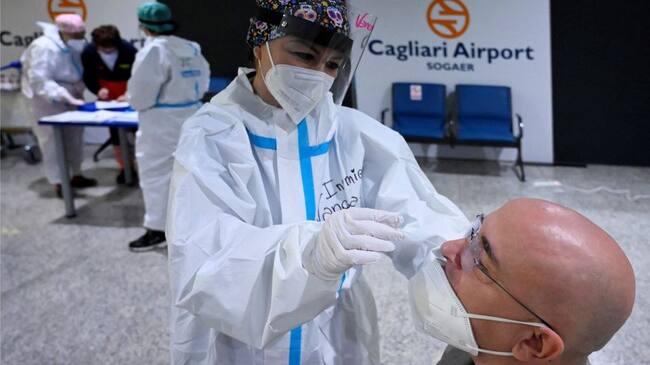 A nurse makes a PCR test to a passenger in the arrival area of Cagliari's airport, on March 15, 2021. - Sardinia is the only Italian region designated as low-risk and escaping Covid-19 restrictions. (Photo by Alberto PIZZOLI / AFP) (Photo by ALBERTO PIZZOLI/AFP via Getty Images)
