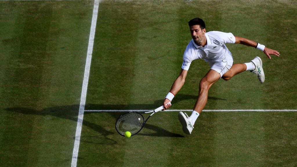 LONDON, ENGLAND - JULY 14: Novak Djokovic of Serbia stretches to play a forehand in his Men's Singles final against Roger Federer of Switzerland during Day thirteen of The Championships - Wimbledon 2019 at All England Lawn Tennis and Croquet Club on July 14, 2019 in London, England. (Photo by Shaun Botterill/Getty Images)