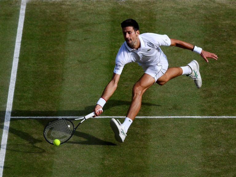 LONDON, ENGLAND - JULY 14: Novak Djokovic of Serbia stretches to play a forehand in his Men&#039;s Singles final against Roger Federer of Switzerland during Day thirteen of The Championships - Wimbledon 2019 at All England Lawn Tennis and Croquet Club on July 14, 2019 in London, England. (Photo by Shaun Botterill/Getty Images)