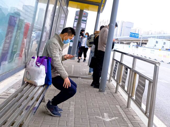 Un trabajador utiliza una máscara en un paradero de buses en la capital de China