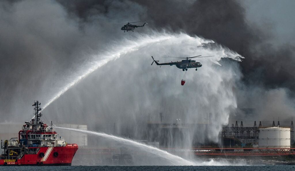 Bomberos y helicópteros atacan las llamas en los tanques de crudo en Cuba