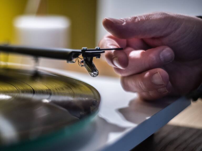 A man playing a turntable vinyl record player in a music store in Paris, on February 18, 2020. (Photo by Martin BUREAU / AFP) (Photo by MARTIN BUREAU/AFP via Getty Images)