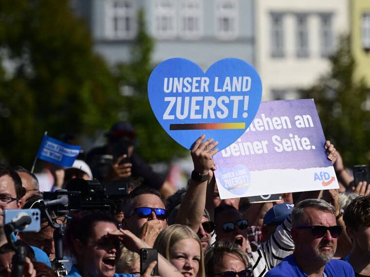 Seguidores de la ultraderecha en Alemania con un cartel "nuestro país primero" del partido AfD en un acto de campaña en el estado de Turingia.
