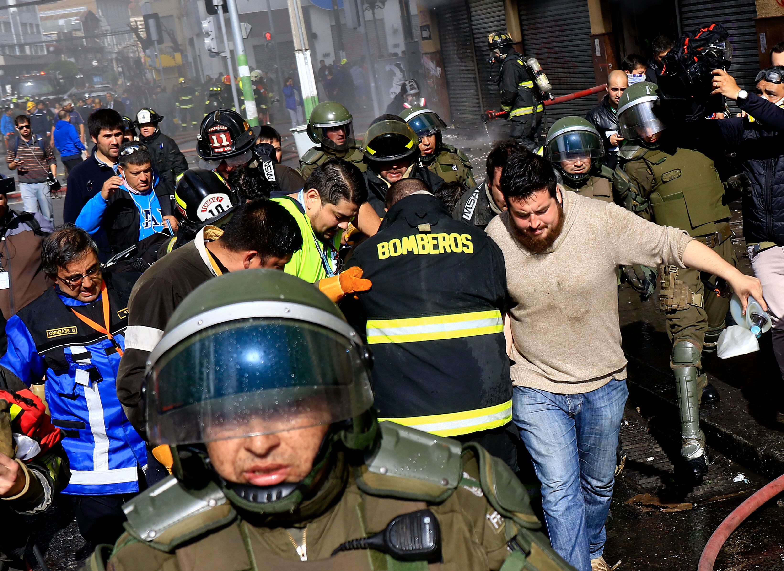 21 de mayo de 2016/VALPARAISOBomberos intenta reanimar a Eduardo Lara que se encontraba al interior del edifico que fue quemado por encapuchados durante la marcha del 21 de mayo en Valparaiso
FOTO:MARIO DAVILA/AGENCIAUNO