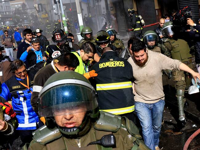 21 de mayo de 2016/VALPARAISOBomberos intenta reanimar a Eduardo Lara que se encontraba al interior del edifico que fue quemado por encapuchados durante la marcha del 21 de mayo en Valparaiso
FOTO:MARIO DAVILA/AGENCIAUNO