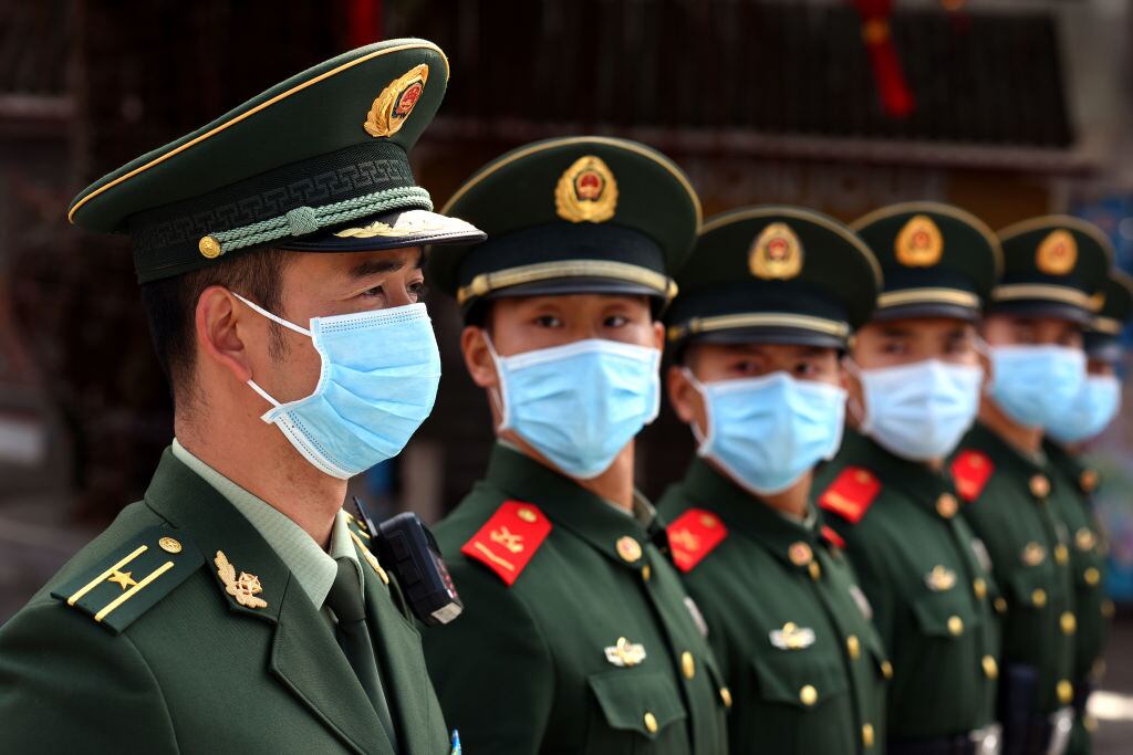 Un grupo de policías militares muestran el uso de mascarillas en China