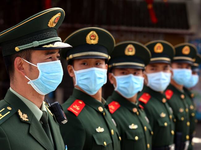 Un grupo de policías militares muestran el uso de mascarillas en China