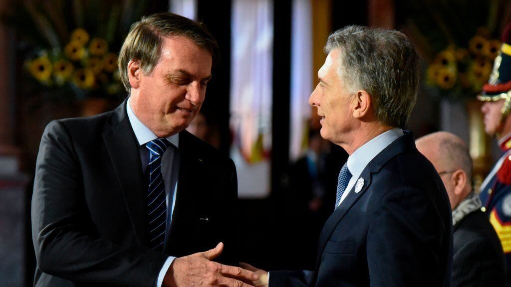 Argentinian President Mauricio Macri (R) greets his Brazilian counterpart Jair Bolsonaro, during the 54th Summit of Heads of State of Mercosur and Associated States in Santa Fe, Argentina on July 17, 2019. (Photo by STRINGER / AFP)        (Photo credit should read STRINGER/AFP via Getty Images)