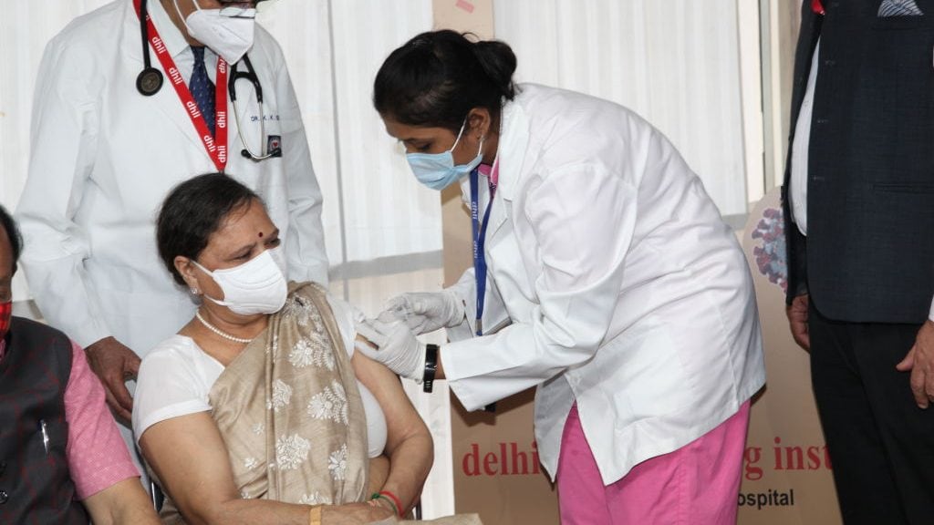 NEW DELHI, INDIA MARCH 2: Mrs Nutan Goel, wife of Indian health and Science Minister Dr Harsh Vardhan receives a Covid-19 vaccine injection of the totally indigenously Indian made Covaxinas on March 2, 2021 in New Delhi, India. This was the first dose, next will be administered after 28 days. After the vaccination he stood by the protection shield and gesticulated his happiness. He also appealed for all eligible citizens to take the vaccine and negate any rumour related to the vaccine. (Photo by Pallava Bagla/Corbis via Getty Images)