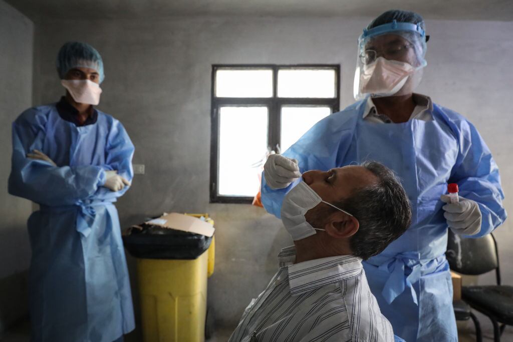 Trabajadores de la salud realizan test del Covid-19 en Siria