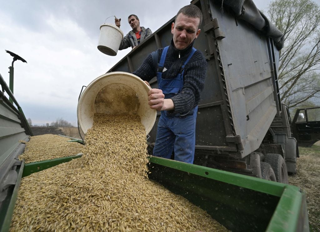 Trabajadores vierten avena en una máquina en las cercanías de Kiev
