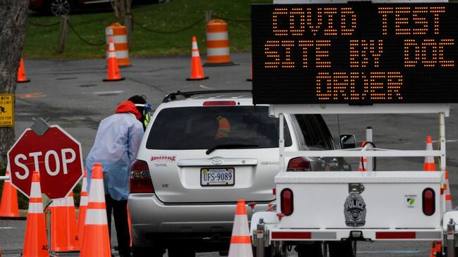 A healthcare worker oversees cars as people arrive to get tested for a Covid-19 test, at a testing site in Arlington, Virginia on December 1, 2020. (Photo by Olivier DOULIERY / AFP) (Photo by OLIVIER DOULIERY/AFP via Getty Images)